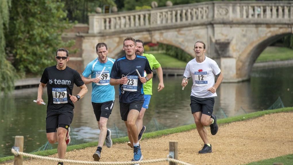 A photo from the 2019 Chariots of Fire of five participants racing alongside the river cam