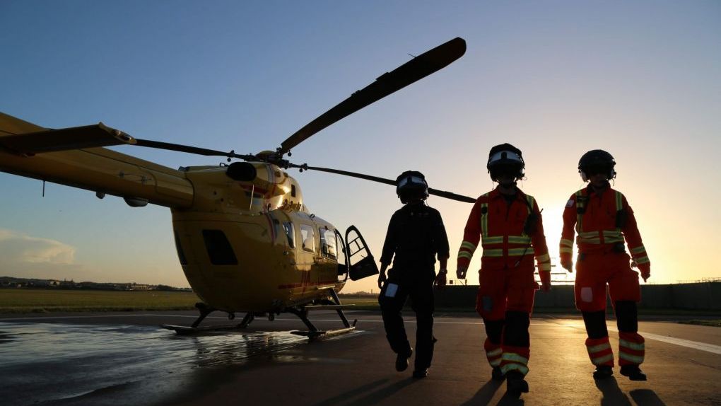 EAAA crew with helicopter at dusk