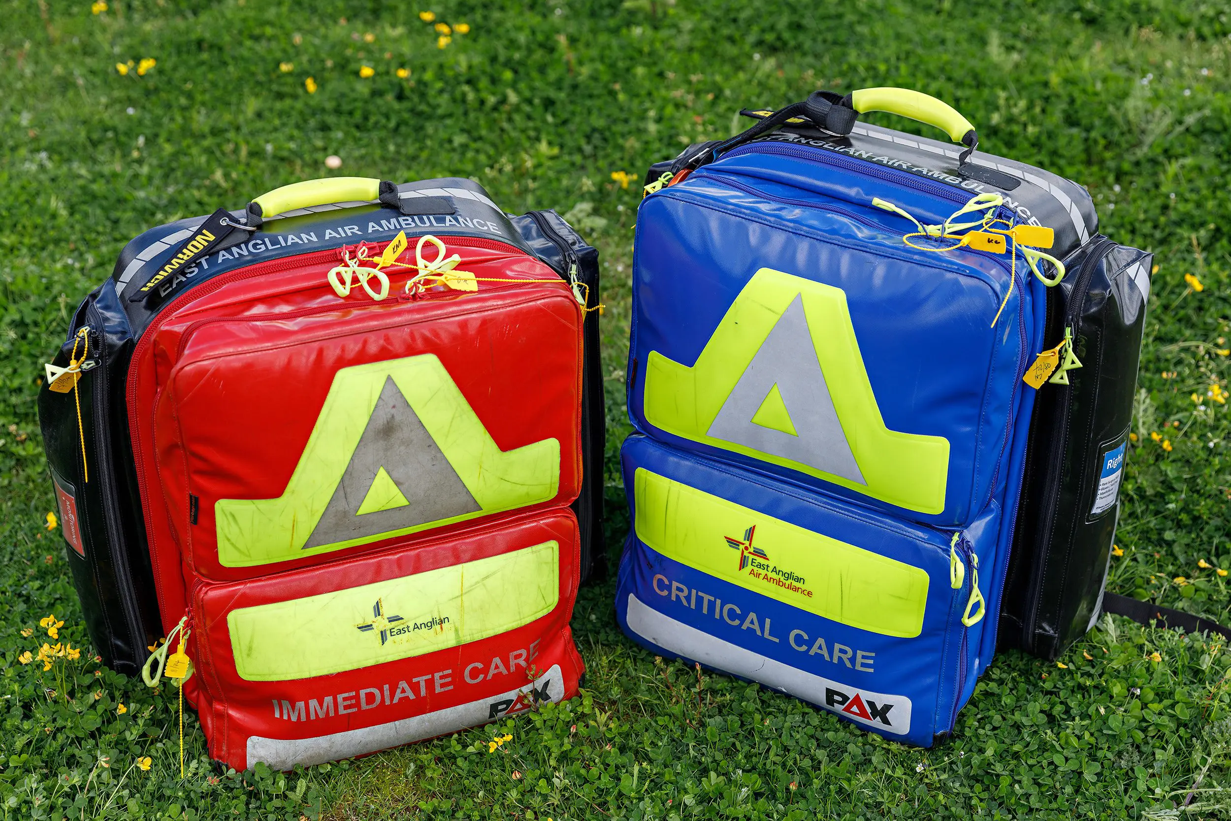 red and blue critical care bags on grass