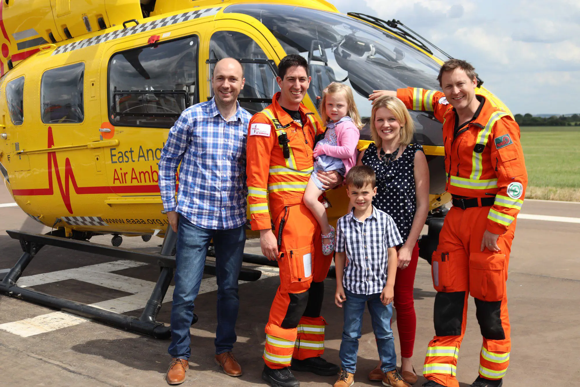 Annabel Brightwell and her family with the EAAA crew in front of the helicopter.