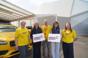 G's Fresh and EAAA Staff holding infront of critical care car