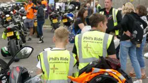 Two young people wearing phil's ride bibs with bike's in background