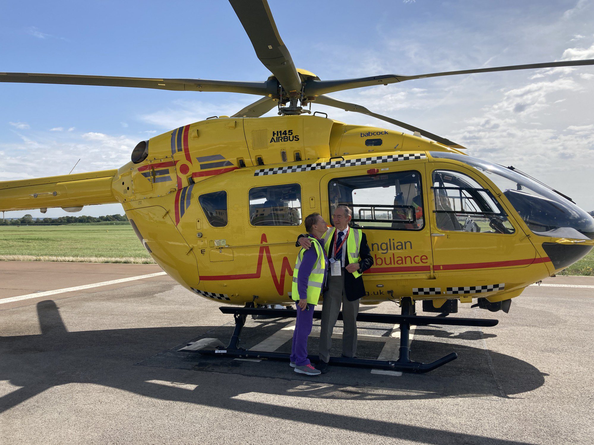 David Durrant and his wife pictured in front of the helicopter during a visit to EAAA's Cambridge base.
