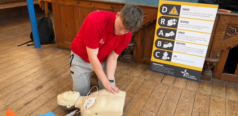 CPR Volunteer Riley White demonstrating chest compressions