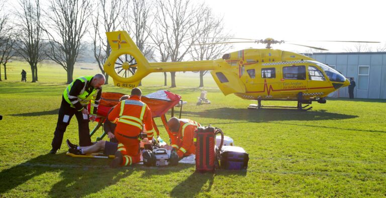 Doctor, paramedic and pilot with patient in a park