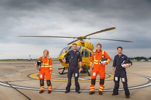 Crew standing in front of Helicopter