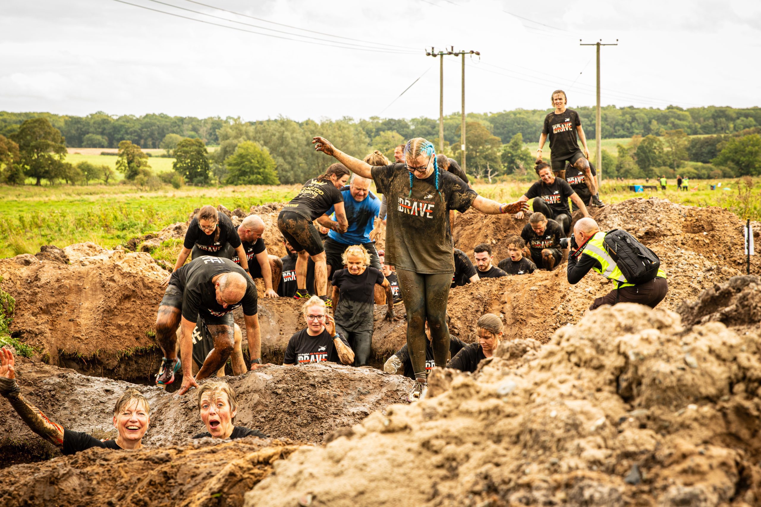 Group of Only the Brave participants climbing in mud