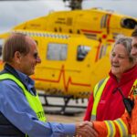 Aftercare patient with crew in front of helicopter