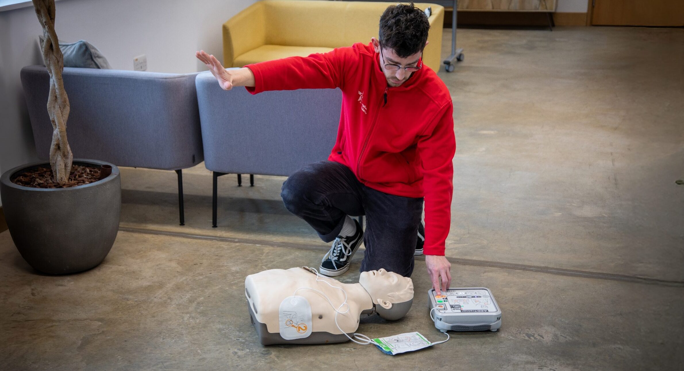 CPR trainer with hand out using AED