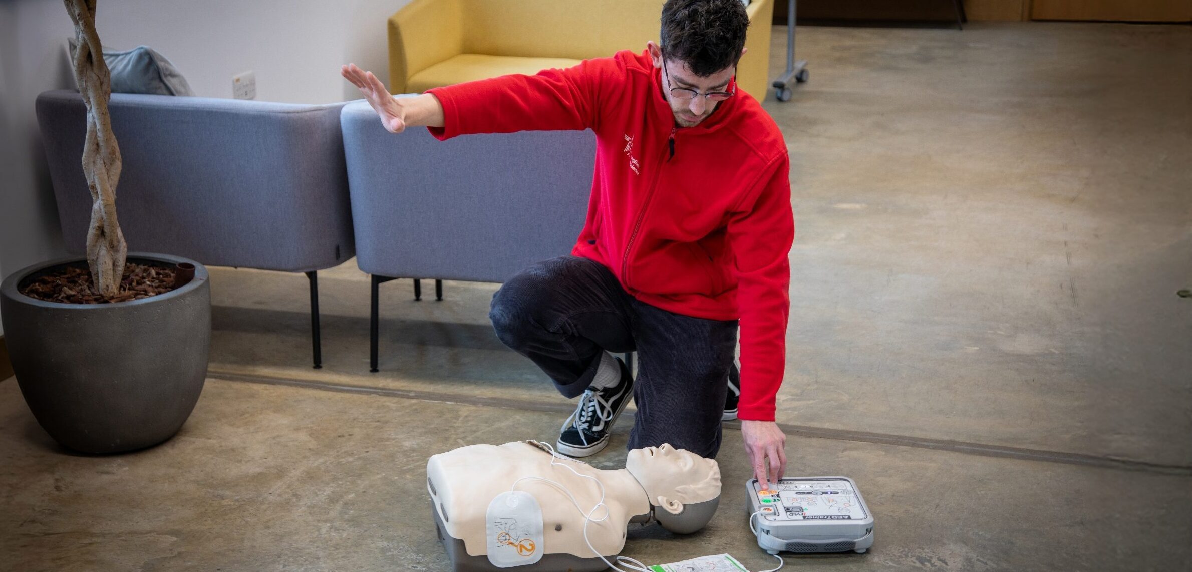 CPR trainer with hand out using AED