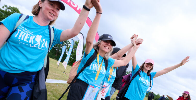 Finishers holding hands crossing finish line